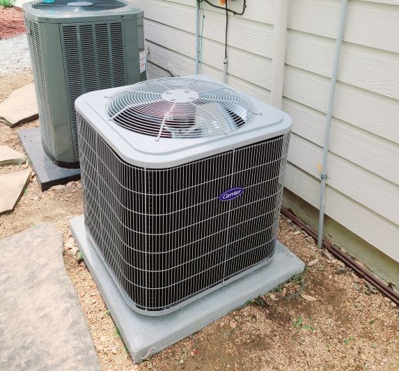 Image of an air conditioning unit, featuring Comfort Conditioning and highlighting AC installation with concrete pads and wired setup for stable and secure operation.