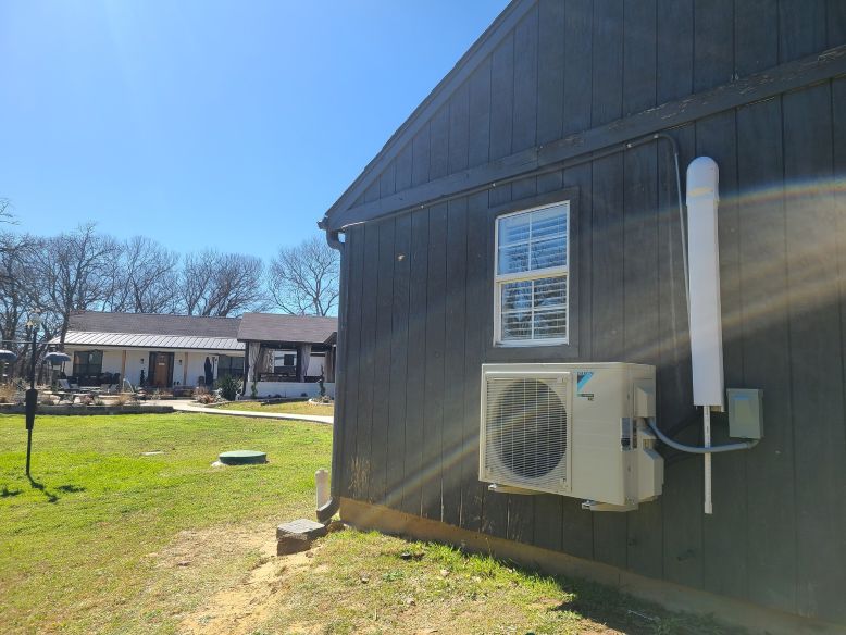 Image of an air conditioning unit, featuring Comfort Conditioning and highlighting AC installation with concrete pads and wired setup for stable and secure operation.