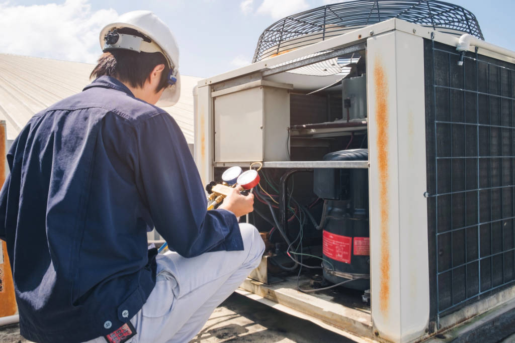 Image of a technician performing a rust inspection and gauge check on an AC unit, featuring Comfort Conditioning and highlighting maintenance procedures for air conditioning systems.