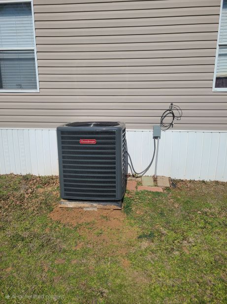 Image of an air conditioning unit, featuring Comfort Conditioning and highlighting AC installation with concrete pads and wired setup for stable and secure operation.