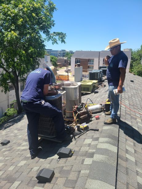 Technicians Maintenance Rooftop AC Unit Image of a technician performing maintenance on a rooftop AC unit, featuring Comfort Conditioning and highlighting expert technician services for commercial HVAC systems..