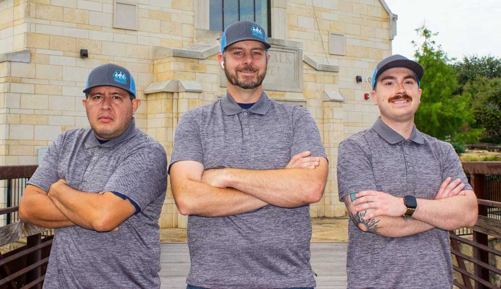 Comfort Conditioning team standing together in front of the company building, smiling and dressed in branded uniforms.
